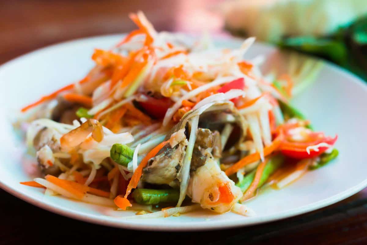 Photo by Pixabay Close-up of a vibrant Thai papaya salad with fresh vegetables and herbs.