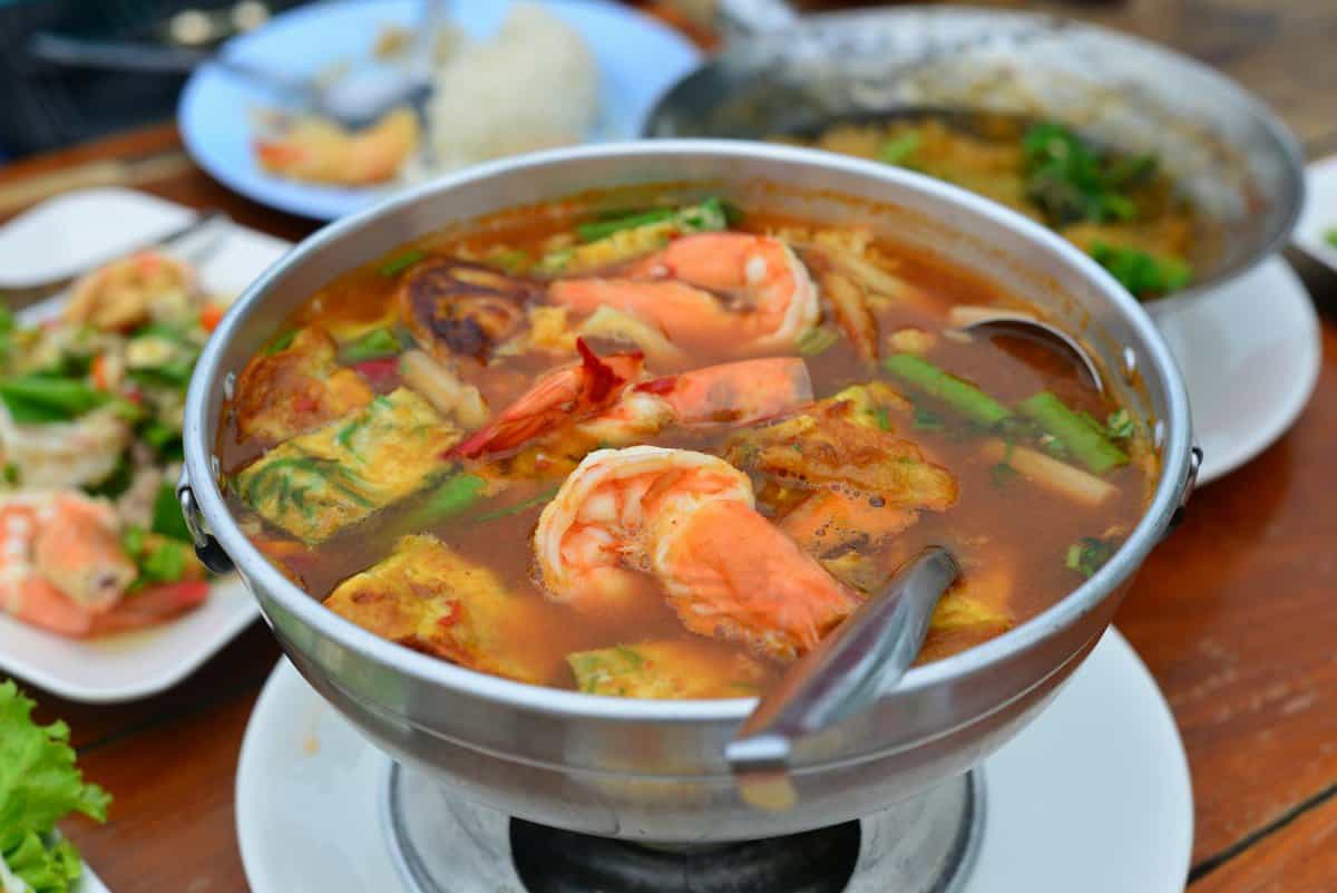 Photo by @ Nine Close-up of a traditional Thai Tom Yum Goong soup with shrimp, known for its spicy flavors.