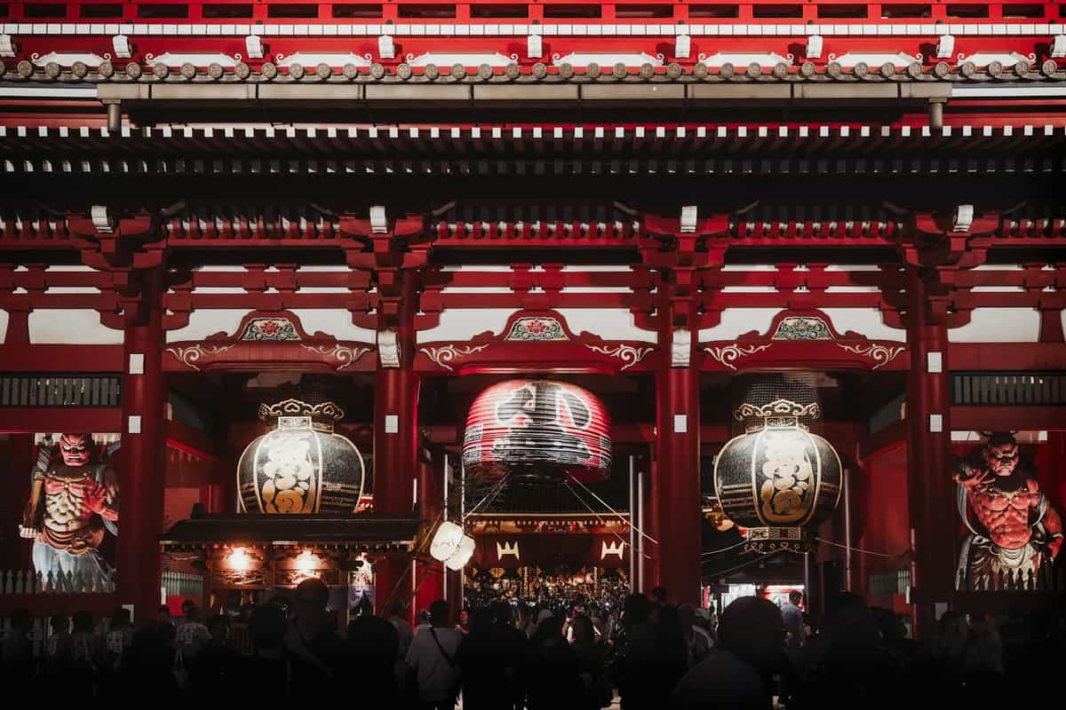 a group of people standing in front of a red building